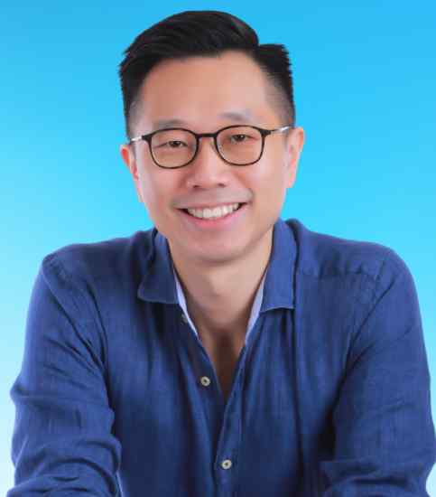 Aron Pang: a man with medium-length hair, dressed casually, smiling at the camera. He stands against a neutral background, exuding a friendly demeanor.