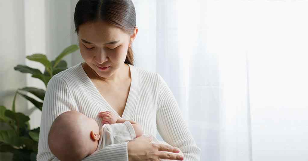 Breastfeeding and its impact on mental health and wellbeing – Hong Kong mum lovingly looks at her infant.