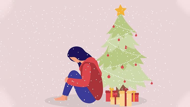 A girl sitting depressed in front of a Christmas tree, reflecting the loneliness and emotional challenges some may face during the holiday season.