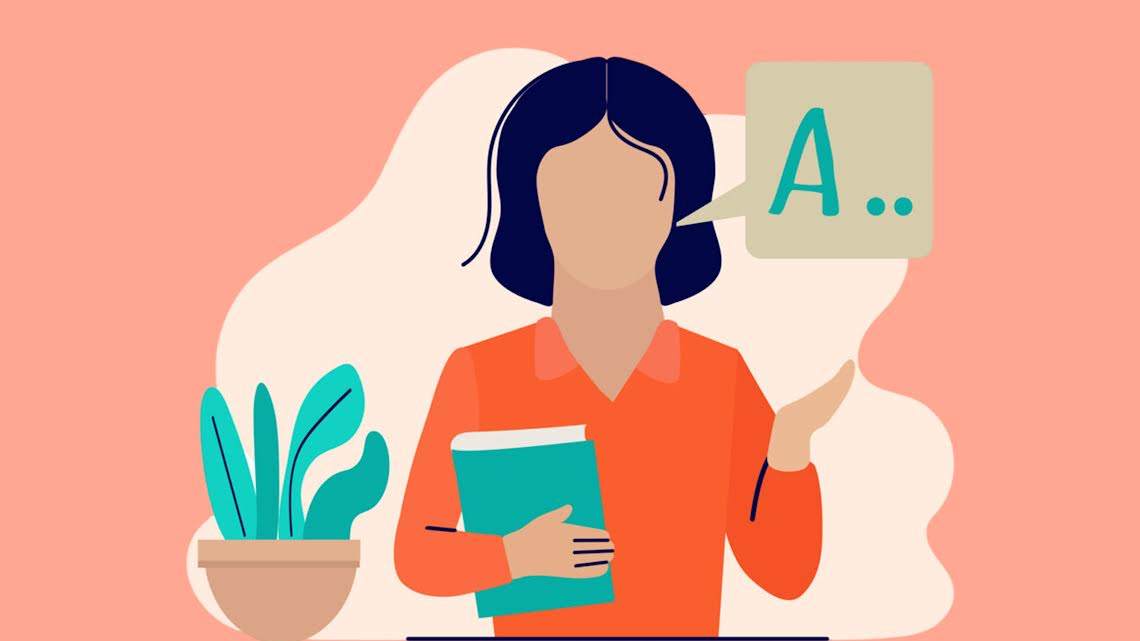 The image is a digital illustration of a woman with dark blue hair, wearing an orange shirt. She is holding a book in one arm while gesturing with her other hand. A speech bubble containing the letter "A.." suggests she is speaking or teaching.