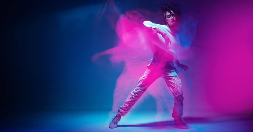 A neon-style photo of a woman, dancing and expressing emotions through movements.